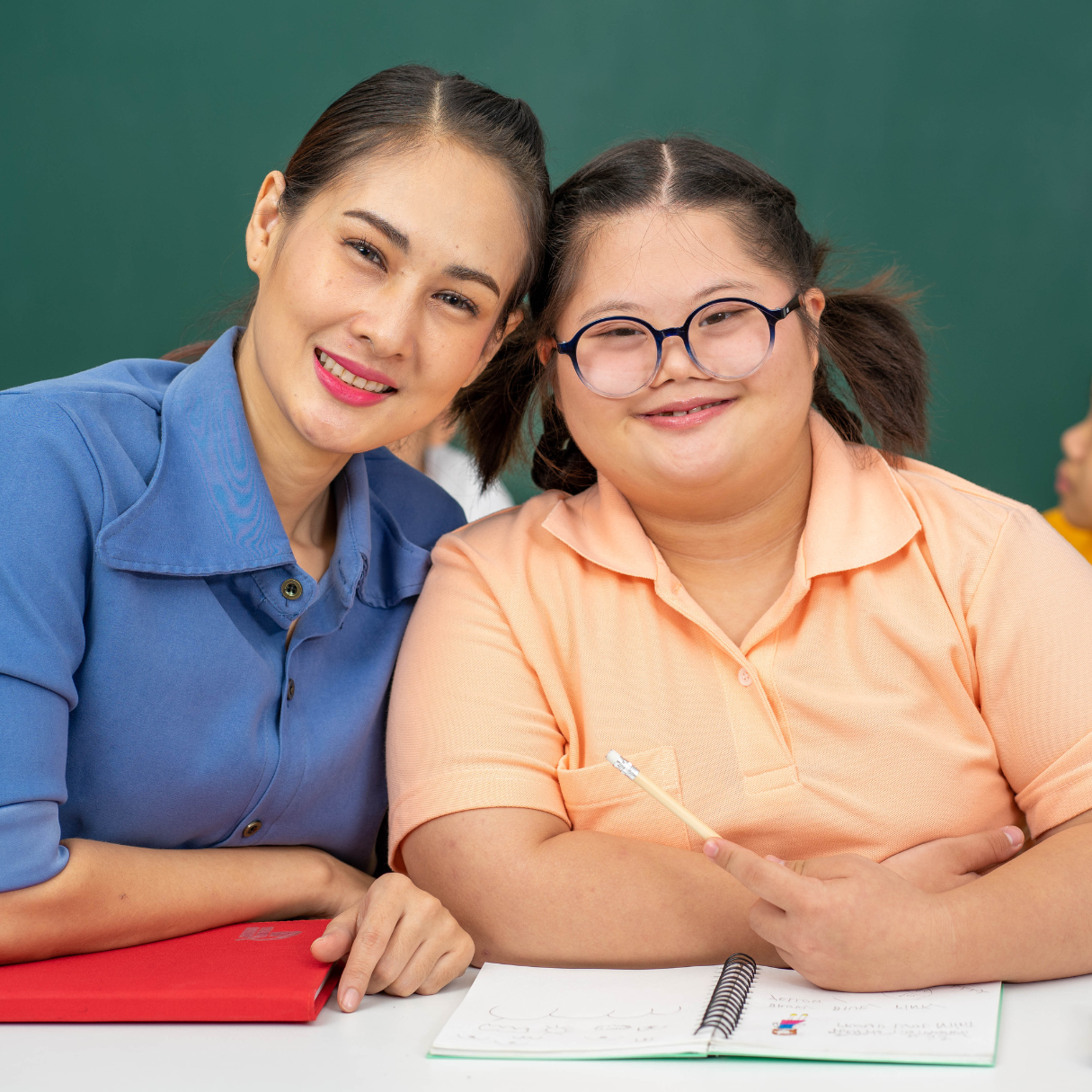 Direct Support Professional and adult customer smiling together during a supported activity