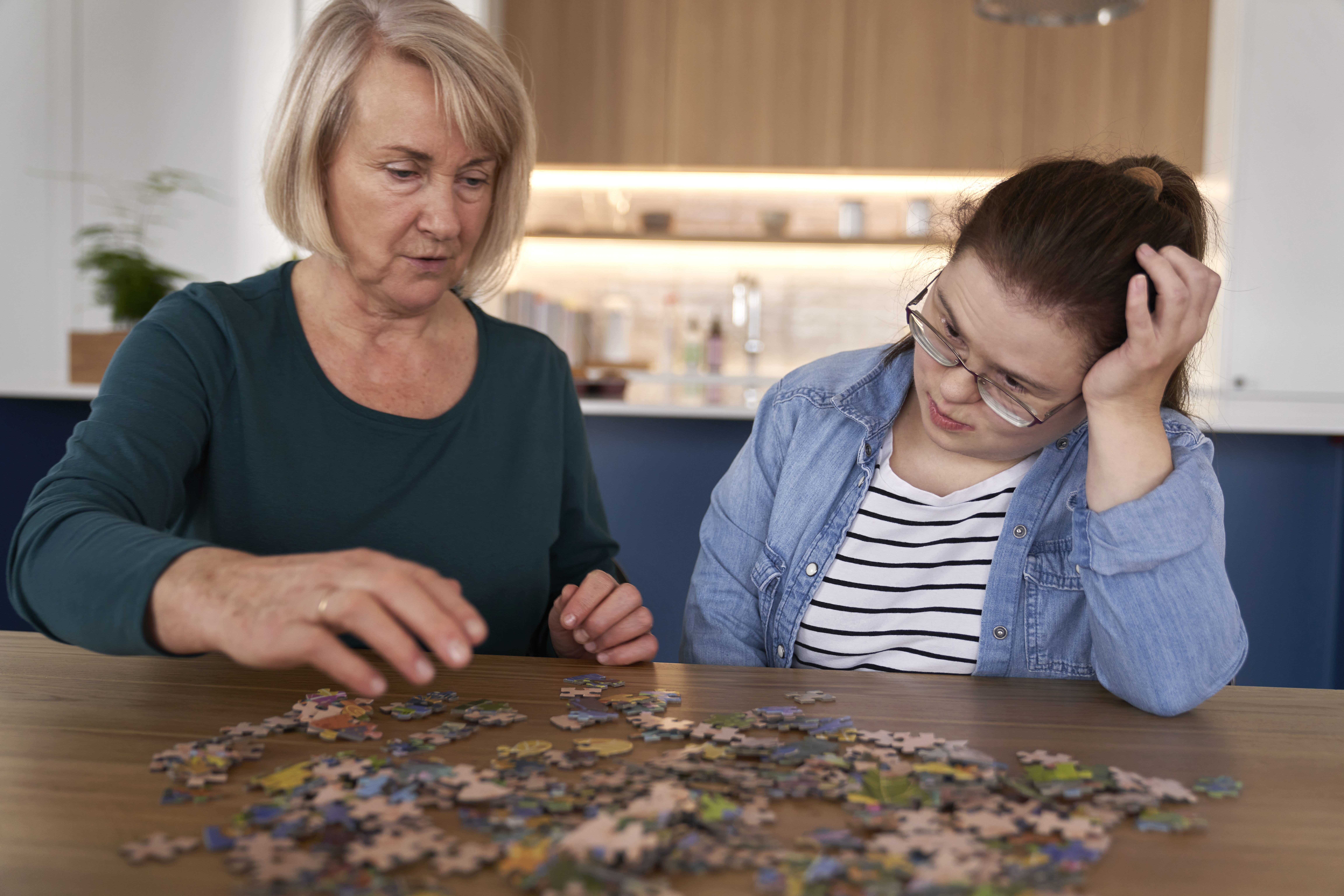 Two women assembling a jigsaw puzzle together as an example of trusted relationship-based support