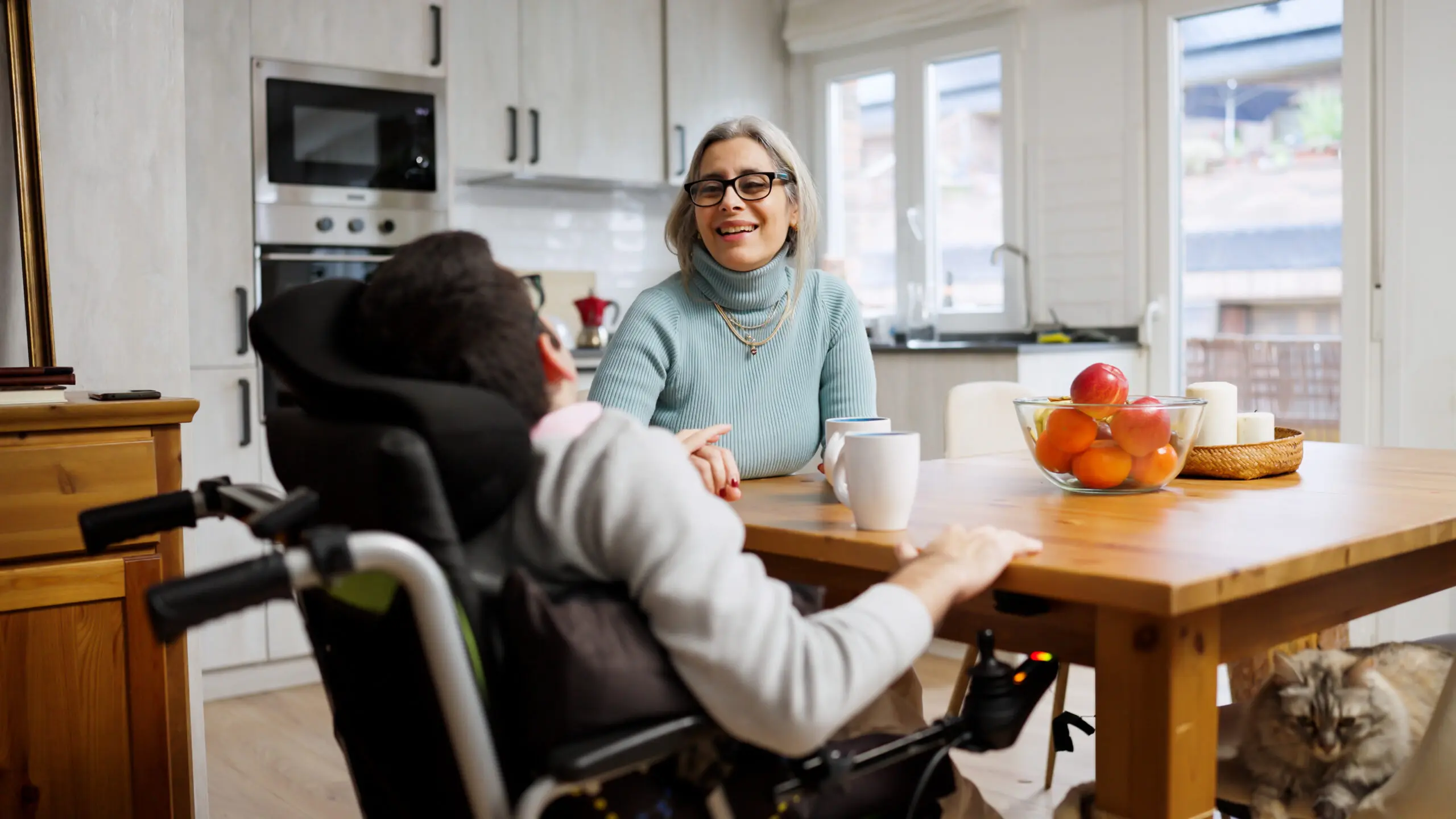 A Direct Support Professional talking with a person who uses a wheelchair
