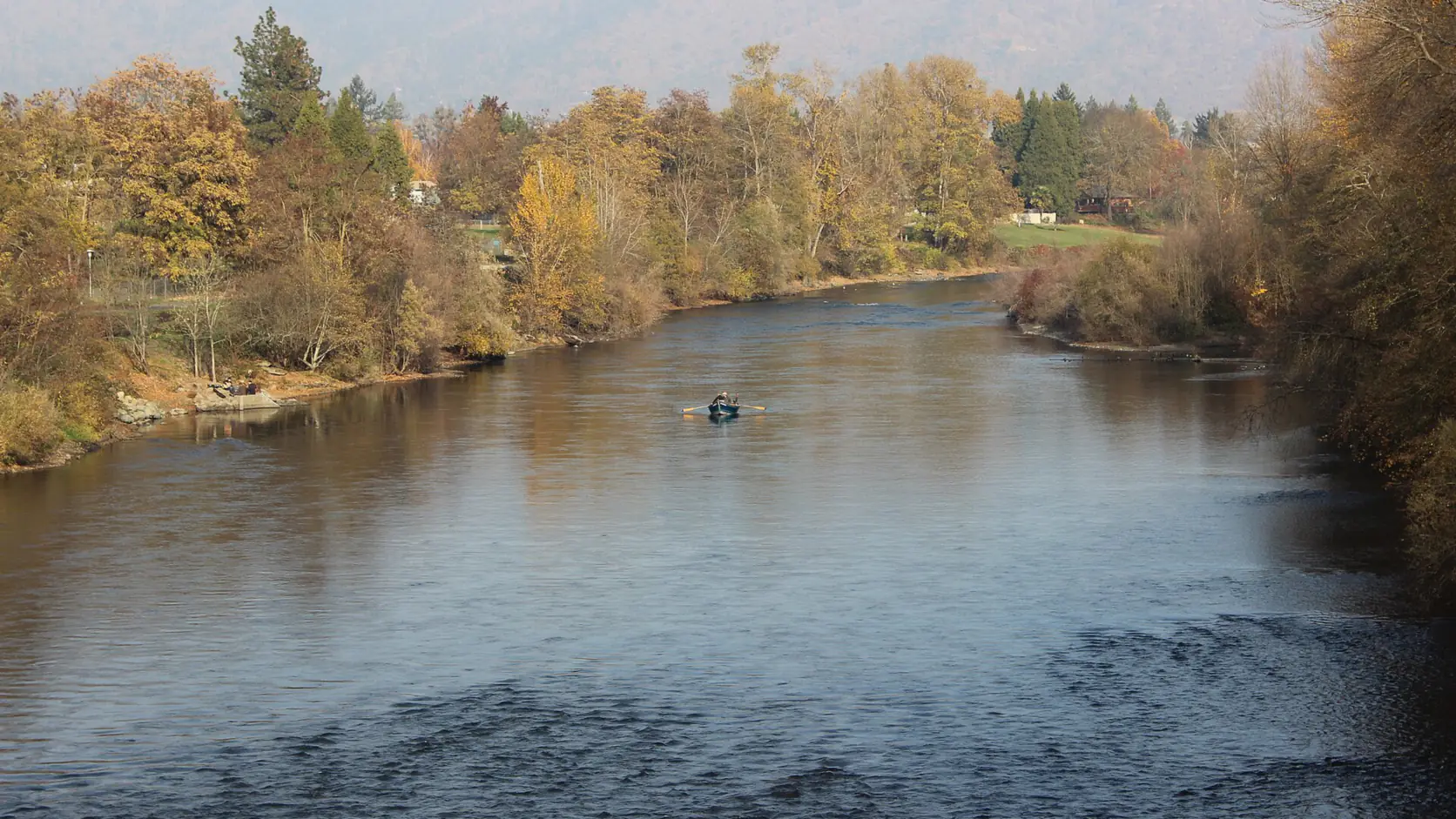The Rogue River running calm past autumn trees at Grants Pass, Josephine County